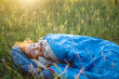 © Ольга Симонова - A child sleeps in a sleeping bag on the grass in a camping trip - eco-friendly outdoor recreation, healthy lifestyle, summer time. Sweet and peaceful sleep. Mosquito bites, repellent.