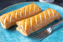 Two Homemade Sausage Rolls On A Turquoise Plate With A Fork
