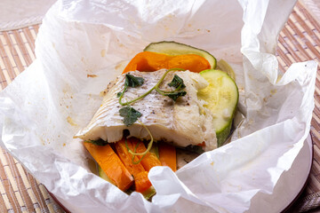 White fish fillet with vegetables in rustic style. Healthy eating: cooked fish fillet with vegetables garnish. Diet food with white fish and vegetables. Steam vegetables with roasted zander fillet