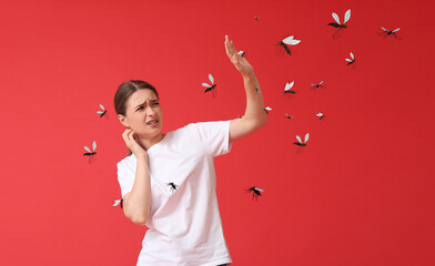 Wall Mural - Young woman and many mosquitoes on red background