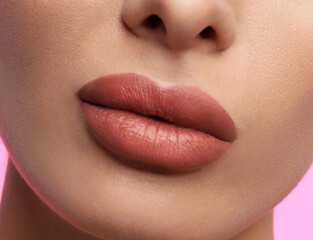 Wall Mural - Woman with beautiful perfect lips after permanent makeup procedure on pink background, closeup