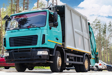 Fototapete - A garbage truck picks up garbage in a residential area. Loading mussar in containers into the car. Separate collection and disposal of garbage. Garbage collection vehicle.