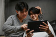 Gay men boyfriends spending time together, enjoy watching something on tablet