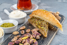 Carrot Slice Baklava (Turkish: Havuc Dilim Baklava) On Wooden Tray. Traditional Baklava From Gaziantep, Turkey. Baklava With Pistachio Served With Icecream,bananas And A Glass Of Tea