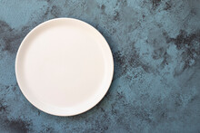 Empty White Plate On Blue Concrete Background. Top View, With Copy Space