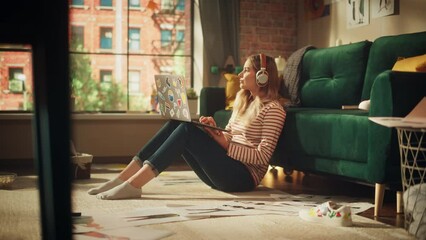 Poster - Blonde Woman Using Laptop Computer, while Sitting on Living Room Floor in Cozy Stylish Apartment. Attractive Girl in Headphones is Pondering and Coding