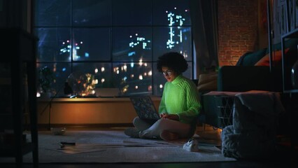 Poster - Young Hispanic IT Specialist Working on Laptop Computer in Creative Evening Environment. Beautiful Diverse Multiethnic Female Sitting at the Floor and Coding