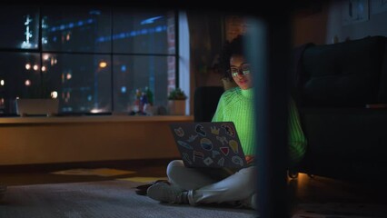 Fototapete - Black Female IT Specialist Coding at her Laptop During the Evening and Check Notification at Smartphone. Diverse Woman have Deadline Late at Night. Millennial People Concept