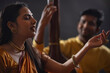 © IndiaPix - Close-up view of a young female musician performing on stage and a man accompanying her on tanpura