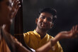 © IndiaPix - Close-up view of a young male musician accompanying a female musician on Tanpura during stage performance