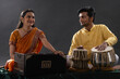© IndiaPix - Man and woman performing together with harmonium and Tabla in a classical musical concert