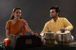 © IndiaPix - Man and woman performing together with harmonium and Tabla in a classical musical concert