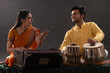 © IndiaPix - Man and woman performing together with harmonium and Tabla in a classical musical concert