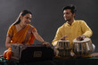 © IndiaPix - Man and woman performing together with harmonium and Tabla in a classical musical concert