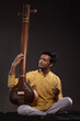 © IndiaPix - Portrait of young man performing with Tanpura at concert