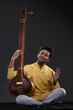 © IndiaPix - Portrait of young man performing with Tanpura at concert
