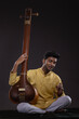 © IndiaPix - Portrait of young man performing with Tanpura at concert