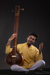 © IndiaPix - Portrait of young man performing with Tanpura at concert