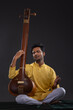 © IndiaPix - Portrait of young man performing with Tanpura at concert
