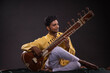 © IndiaPix - Portrait of young man performing with Sitar at concert