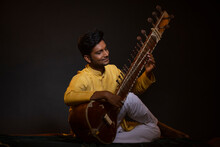 Portrait Of Young Man Performing With Sitar At Concert