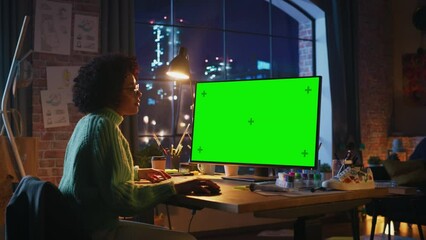 Poster - Latin Professional Female Freelancer Working on Desktop Computer with Green Chromakey Screen and Looking Attentively. Woman Scrolling With Computer Mouse while Finished her Project at Evening