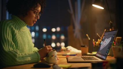 Poster - Female Designer Puts Patterns on Shoe Comparing with 3D Model on the Laptop Screen. Black Woman Feel Inspired while Drawing at Evening. Creating Trendy Things Concept. Slow Motion Shot