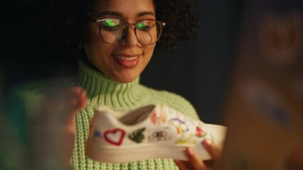 Aufkleber - Portrait Shot of Multiracial Teenage Designer Creating New Sneakers at Evening. Female Artist is Customising Hype Shoes by Adding Own Design. Trends in Footwear Design Concept. Close Up