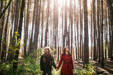 Young Couple Holding Hands In Autumn Forest In Canada