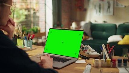 Poster - Concentrated Male Art Director Working From Home at Laptop with Green Screen. Man Using Touchpad with Serious Face while Thinking About New Project. Freelance and Millennial People Concept