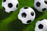 Fototapeta Sport - Several soccer balls on a green grass field. Start Qatar 2022.