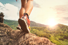 Closeup Of Man Trail Running On Rocky Terrain. Closeup Of Male Feet Run Through Rocky Terrain. Focus On Shoes..
