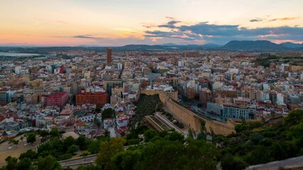 Wall Mural - Alicante, Spain. Aerial view of Alicante, Spain in the evening. It is a popular summer resort of Costa Blanca. Time-lapse, illumination at sunset. Mountains at the background