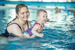 © Olha Tsiplyar - Smiling happy mother with baby girl in swimming pool. Sport, training and family concept