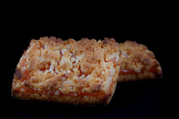 Two orange cookies on a dark background .