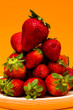 Fresh strawberries on orange background