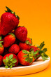 Fresh strawberries on orange background