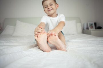 A close shot of the feet of a 4 year old little boy. A happy child is playing in his room. Cozy home.