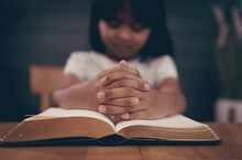 Little Girl Praying With Bible In Church