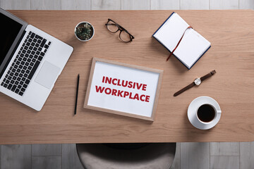 Wall Mural - Inclusive workplace. Wooden table with laptop, cup of coffee and stationery indoors, flat lay