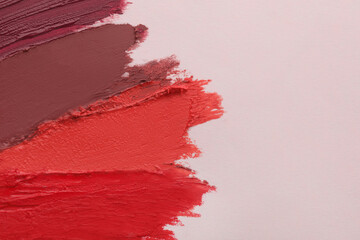 Sticker - Smears of different beautiful lipsticks on light background, top view. Space for text