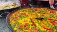 Steam Rising From Vegetarian Paella That Is Being Cooked In A Large Pan At Outdoor Food Market. Traditional Spanish Food.