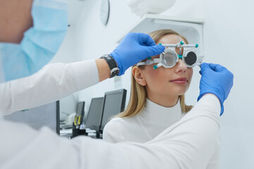 Eye Exam. Woman In Glasses Checking Eyesight At Clinic. Close-up Of Optometrist Checking Female Patient Vision With Trial Frame At Eye Clinic. Diagnostic Concept