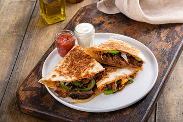 Wall Mural - Brisket, peppers and onions quesadillas cut on a plate