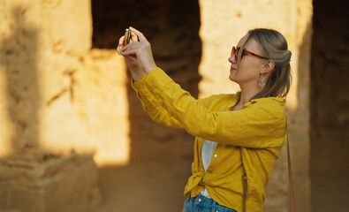 Wall Mural - Woman shooting video via smartphone on excursion.