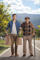 Poster - Young man helping a senior outdoors and carrying groceries