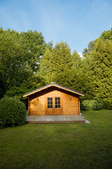 Small cottage in the countryside. Garden house made of wood. Cottage in your own garden for hobbies and free time during the pandemic. Shed in a large garden in Germany