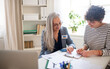 © Halfpoint - Senior woman volunteer helping Ukrainian woman to fill in forms at asylum centre.