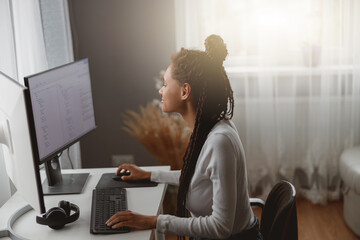 Wall Mural - young concenrated woman coder working on computer at home coding java script algorithm