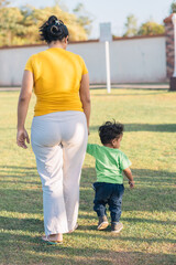 mom walking with the baby on her back in the field